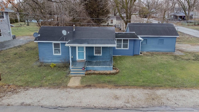 view of front of house with roof with shingles and a front lawn