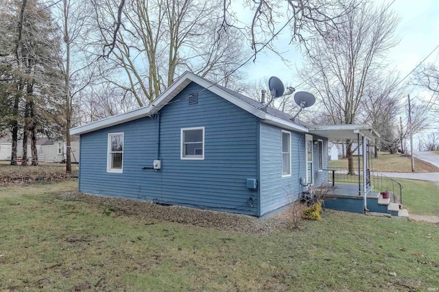 view of side of home featuring a porch and a yard