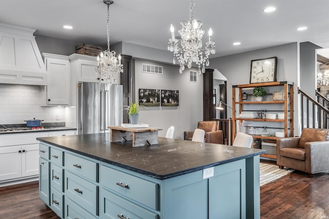 kitchen with visible vents, dark countertops, custom range hood, appliances with stainless steel finishes, and dark wood-type flooring