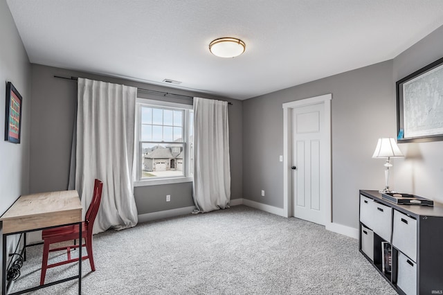 office space with baseboards, visible vents, and light colored carpet