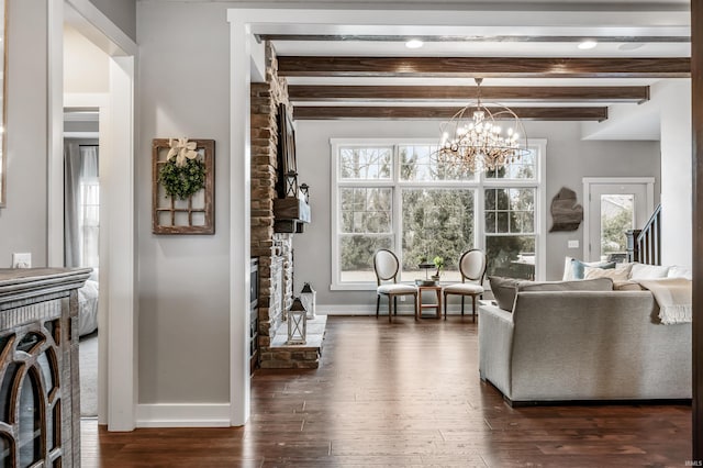 living room featuring a notable chandelier, dark wood-type flooring, beam ceiling, and baseboards