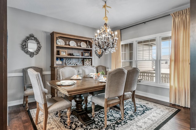 dining space with a chandelier, dark wood-style flooring, and baseboards