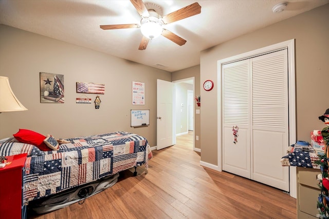 bedroom featuring a closet, visible vents, light wood-style flooring, a ceiling fan, and baseboards