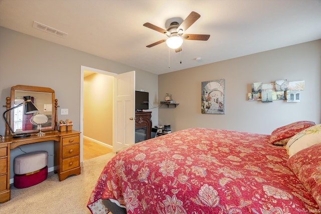 bedroom featuring light carpet, visible vents, and a ceiling fan