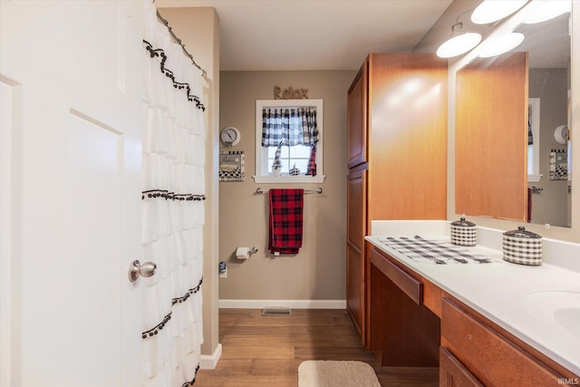 full bath featuring visible vents, baseboards, wood finished floors, curtained shower, and vanity