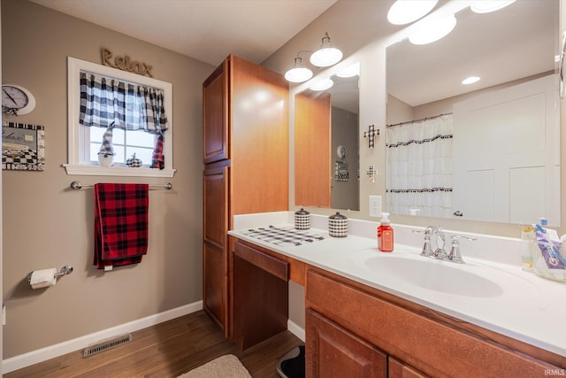 full bathroom with visible vents, a shower with shower curtain, vanity, wood finished floors, and baseboards