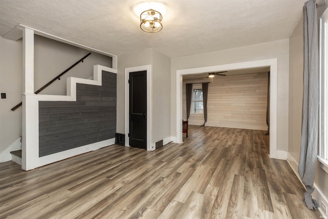 interior space featuring a textured ceiling, stairway, and wood finished floors