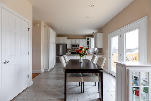 dining area with beverage cooler, light tile patterned flooring, and baseboards