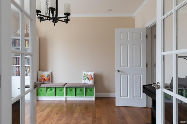 rec room with baseboards, wood finished floors, crown molding, french doors, and a chandelier