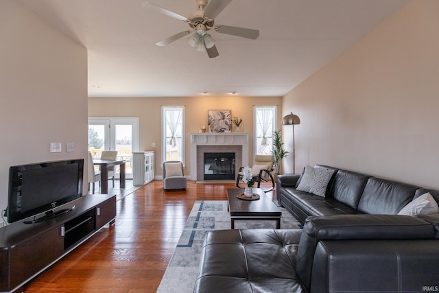 living room with plenty of natural light, ceiling fan, wood finished floors, and a tile fireplace