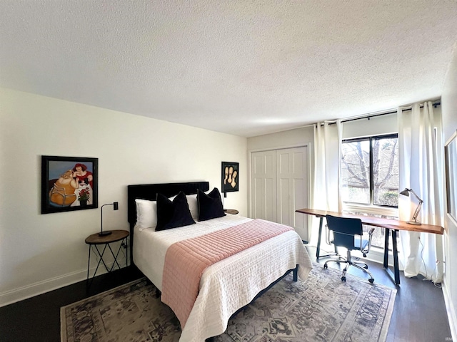 bedroom with a textured ceiling, a closet, wood finished floors, and baseboards