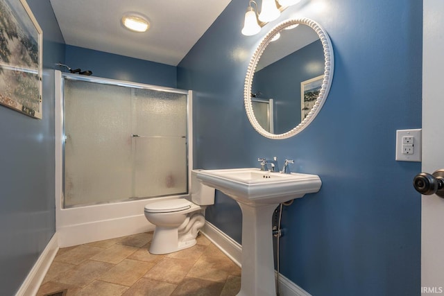 bathroom featuring shower / bath combination with glass door, toilet, and baseboards