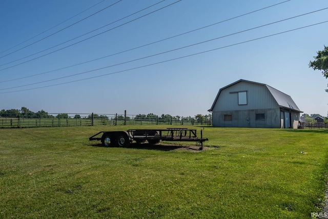 view of yard featuring an outbuilding, a barn, and fence