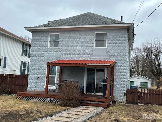 back of property featuring fence and roof with shingles