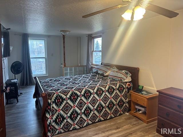 bedroom with ceiling fan, a textured ceiling, and wood finished floors