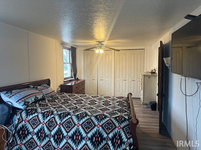 bedroom with dark wood-style floors, a closet, ceiling fan, and a textured ceiling