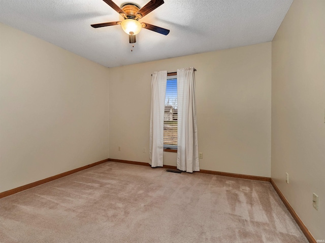 empty room featuring baseboards, a textured ceiling, visible vents, and light colored carpet