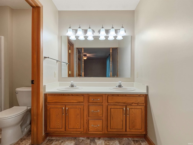 full bath with a sink, toilet, and double vanity