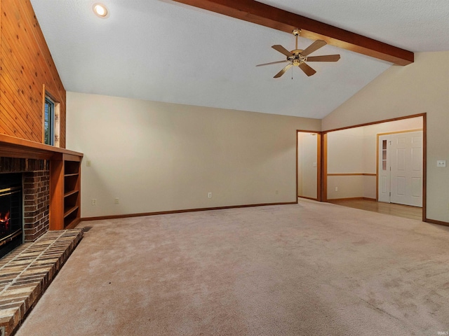 unfurnished living room featuring carpet, beam ceiling, a ceiling fan, a brick fireplace, and wooden walls