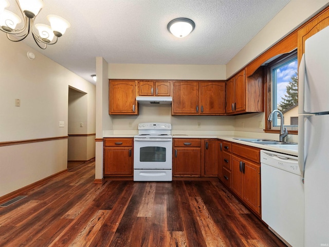 kitchen with light countertops, white appliances, a sink, and under cabinet range hood