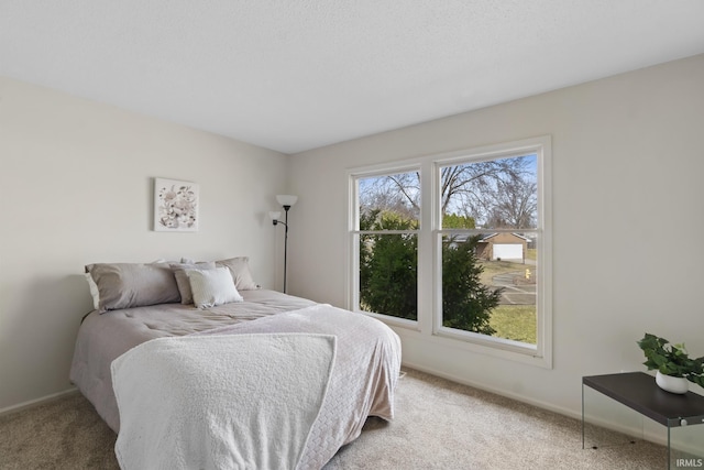 bedroom with carpet, multiple windows, and baseboards