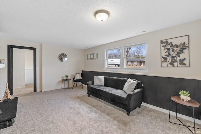 carpeted living area with a textured ceiling and visible vents