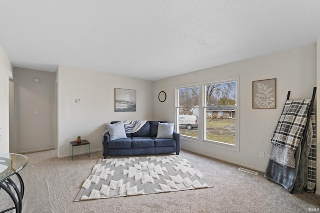 living area featuring carpet, visible vents, and baseboards