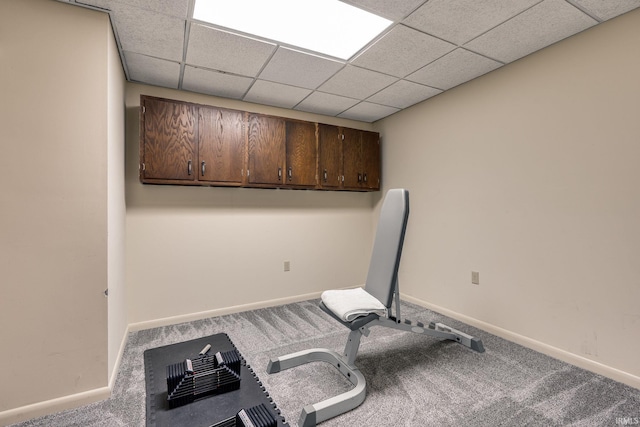 workout area featuring a paneled ceiling, baseboards, and carpet