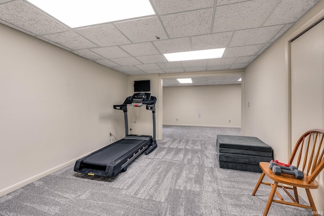 workout area with carpet, a paneled ceiling, and baseboards