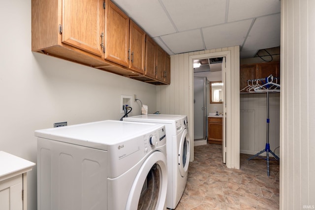 washroom featuring independent washer and dryer and cabinet space