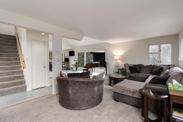 living room featuring lofted ceiling and stairway