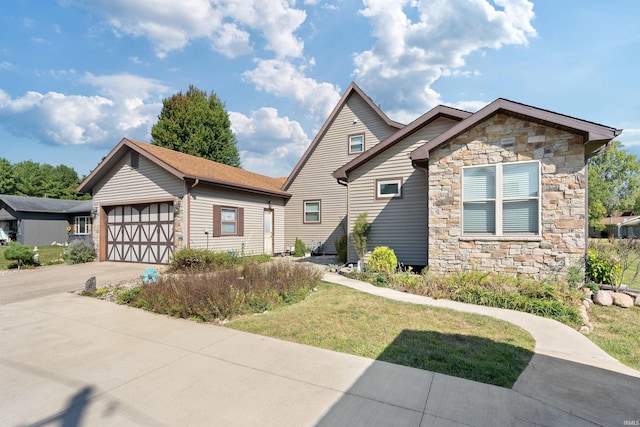 view of front of property with a garage, concrete driveway, stone siding, and a front yard