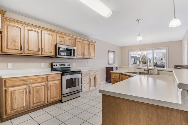 kitchen featuring appliances with stainless steel finishes, decorative light fixtures, a sink, light countertops, and a notable chandelier