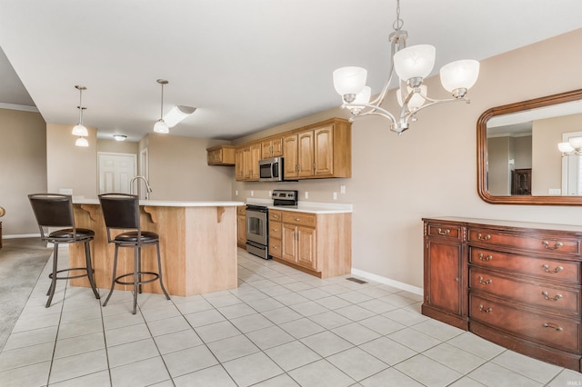 kitchen featuring stainless steel appliances, light countertops, an inviting chandelier, light tile patterned flooring, and a kitchen breakfast bar