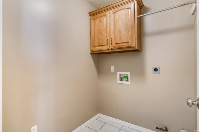 clothes washing area featuring light tile patterned floors, hookup for a washing machine, hookup for an electric dryer, hookup for a gas dryer, and cabinet space