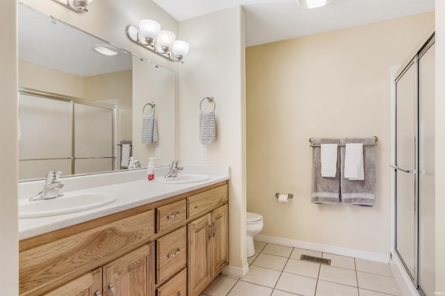 bathroom with a shower stall, a sink, and tile patterned floors