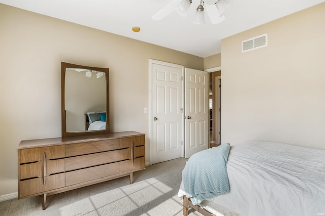 bedroom with a ceiling fan, light colored carpet, visible vents, and baseboards