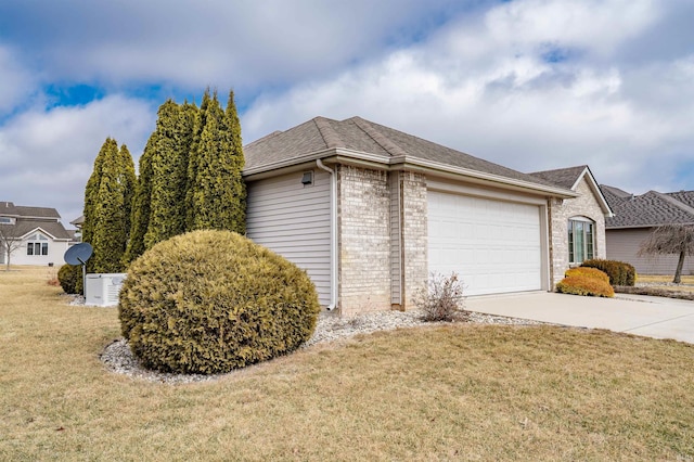 view of home's exterior featuring an attached garage, brick siding, a shingled roof, concrete driveway, and a lawn