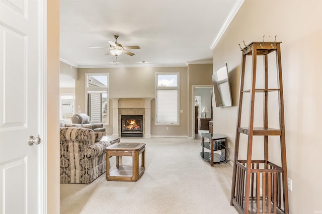 living area featuring light carpet, ceiling fan, ornamental molding, and a fireplace