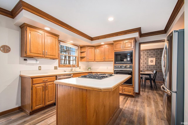 kitchen with black appliances, wood finished floors, a sink, and light countertops