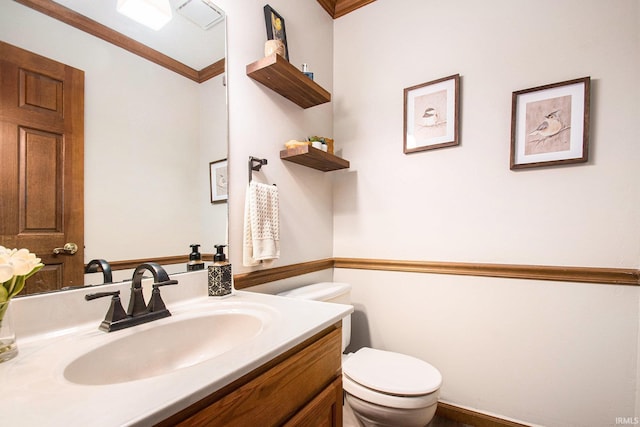 bathroom featuring crown molding, vanity, and toilet