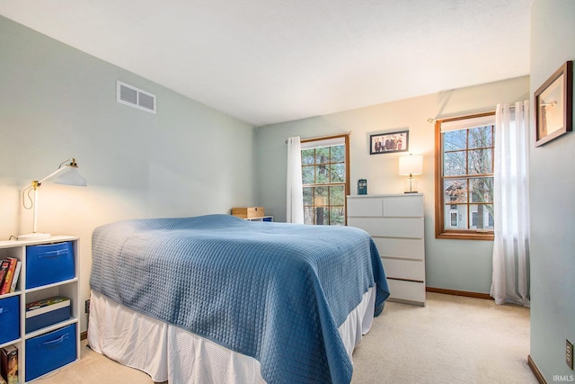 bedroom with carpet floors, visible vents, baseboards, and multiple windows