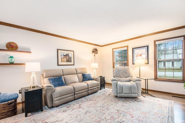 living area with visible vents, crown molding, baseboards, and wood finished floors