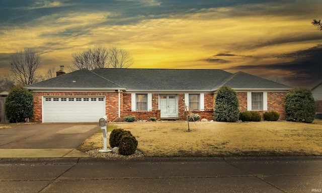 ranch-style house featuring an attached garage, roof with shingles, aphalt driveway, and brick siding