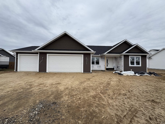 view of front of property featuring a garage and dirt driveway