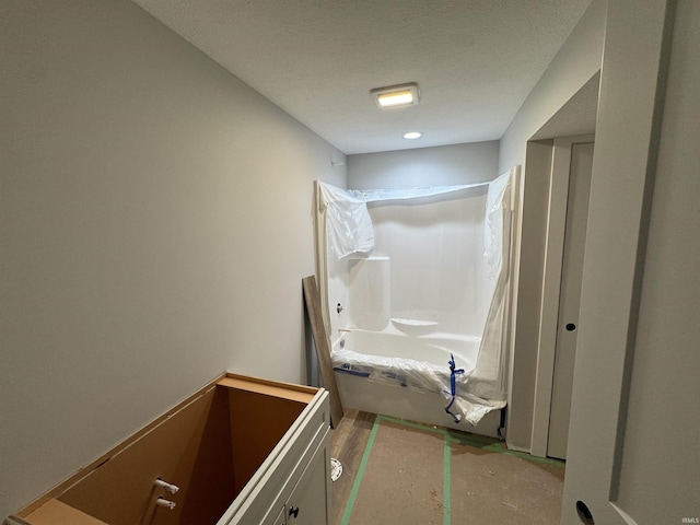 bathroom featuring shower / bathtub combination and a textured ceiling