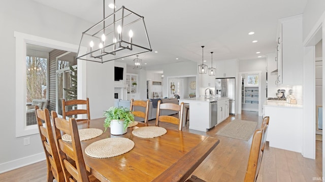 dining area with recessed lighting, baseboards, a fireplace, and light wood finished floors