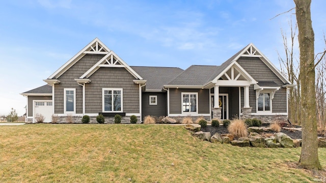 craftsman-style house featuring a garage, stone siding, and a front yard