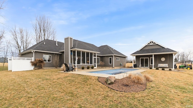 back of property with a yard, a sunroom, a patio area, and fence