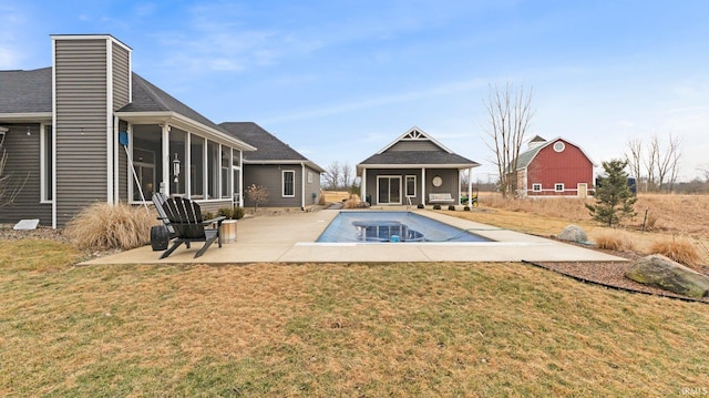 view of swimming pool featuring a storage structure, an outdoor structure, a sunroom, a yard, and a patio area